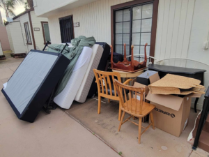 A large pile of mattresses, furniture, and boxes awaiting pickup by Dos Muchos Junk Removal LLC in San Diego, CA.