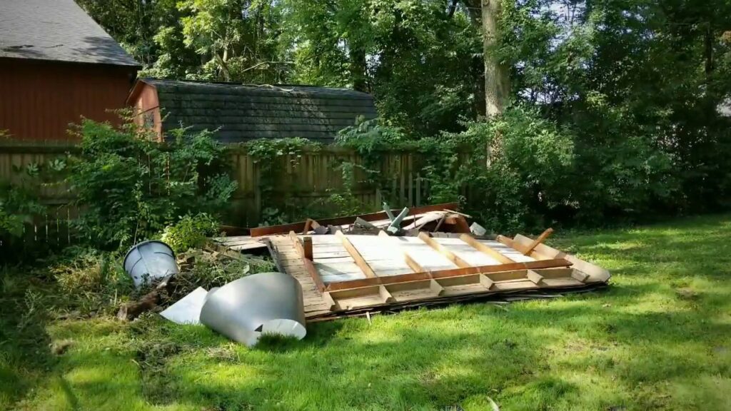 A pile of broken shed debris and other junk in a backyard, ready for removal by Schott Services in Indianapolis, IN.