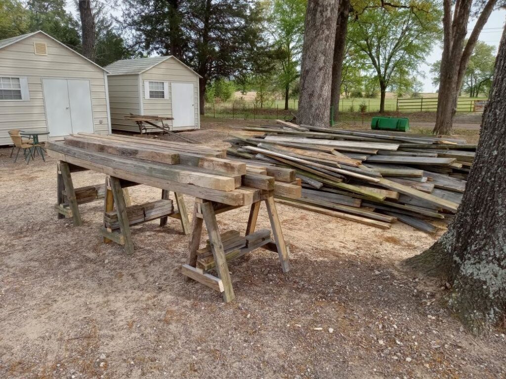 A large pile of old wood planks and lumber debris in a yard, ready for removal by NTX Haul Away Junk Removal in Fort Worth, TX.