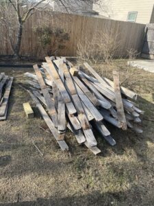 A large pile of old wooden planks and pallets ready for debris removal by Silverhull Junk Removal in San Antonio, TX.