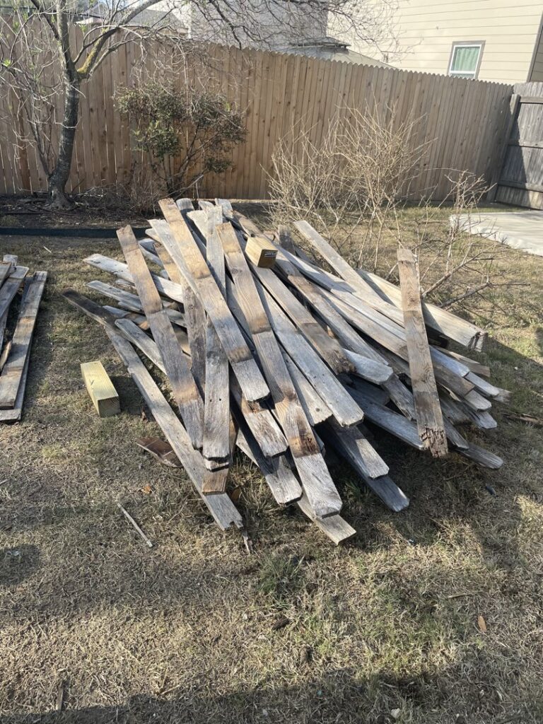 A large pile of old wooden planks and pallets ready for debris removal by Silverhull Junk Removal in San Antonio, TX.