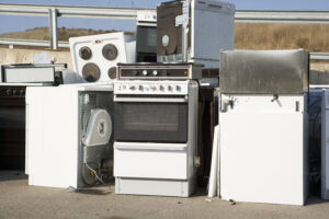 A pile of old appliances including stoves and washing machines, ready for removal by Epic Junk Removal SD in San Diego, CA.