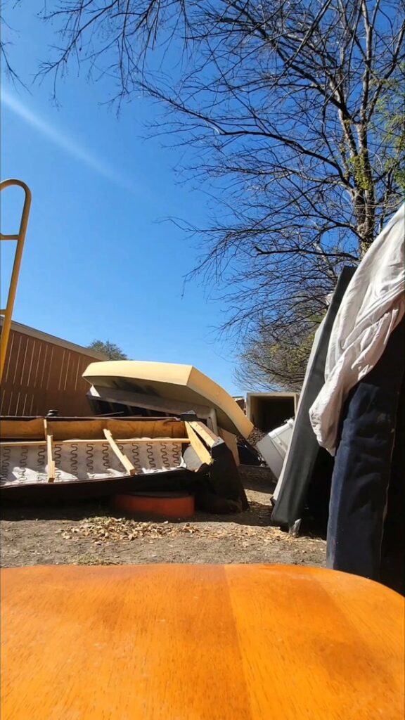 A pile of tree branches and yard waste in a residential front yard, awaiting removal by Your Junk My Trunk Junk Removal in San Antonio, TX.