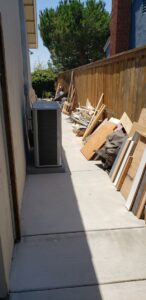 A pile of wood and other debris along a fence, ready for junk removal by 24/7 Junk Removal in Rolling Hills Estates, CA.