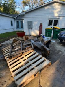 A pile of wooden pallets and other debris outside a house, ready for removal by ABC Junk Removal & Hauling in Westfield, IN.