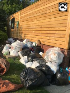 Piles of trash bags and junk against a residential fence, ready for removal by We Haul It Cleaning Service LLC in Canal Winchester, OH.