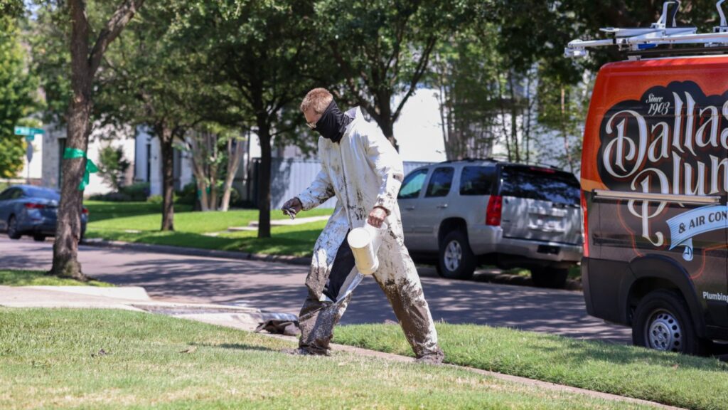A plumber from Dallas Plumbing Company carrying pipes after completing drain or sewer line work in Dallas, TX.