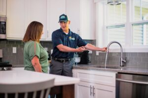 An Apex Pros Plumbing, Electric, Heating, and Air plumber consulting with a customer about a kitchen sink in Columbus, OH.