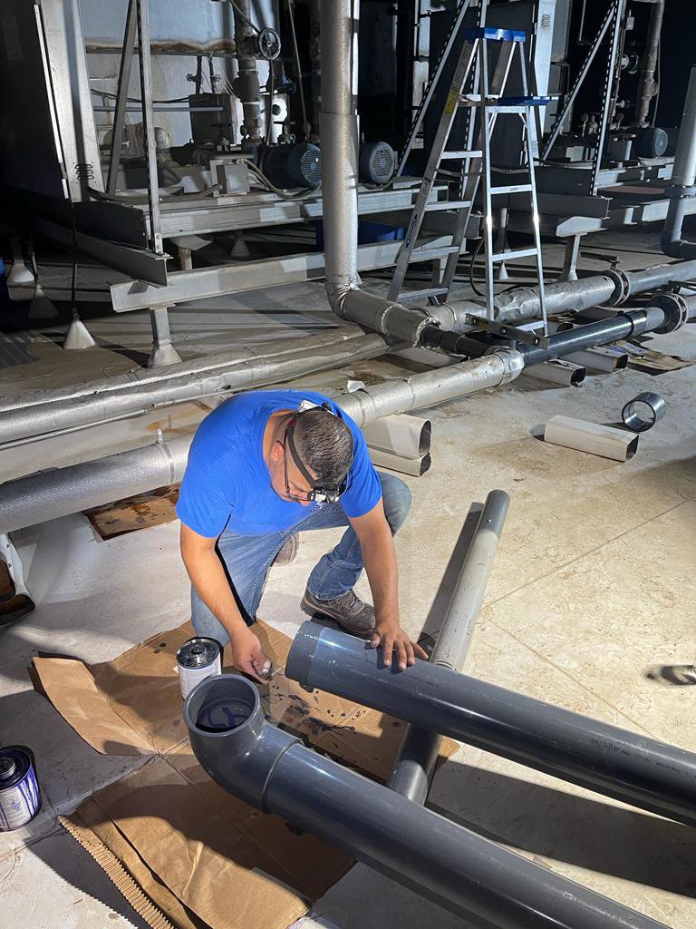 A plumber from Plumbing Services Inc. installing large PVC pipes for a commercial plumbing system in San Diego, CA.