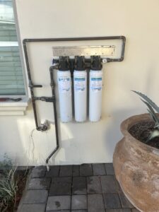 A plumber from JP Plumbing using a jackhammer to work on a commercial drain in a kitchen in Phoenix, AZ