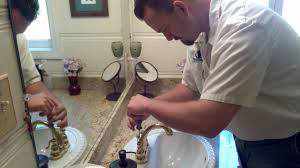 A plumber repairing a bathroom faucet at a client's home for Reliable Plumbing Services in Houston, TX