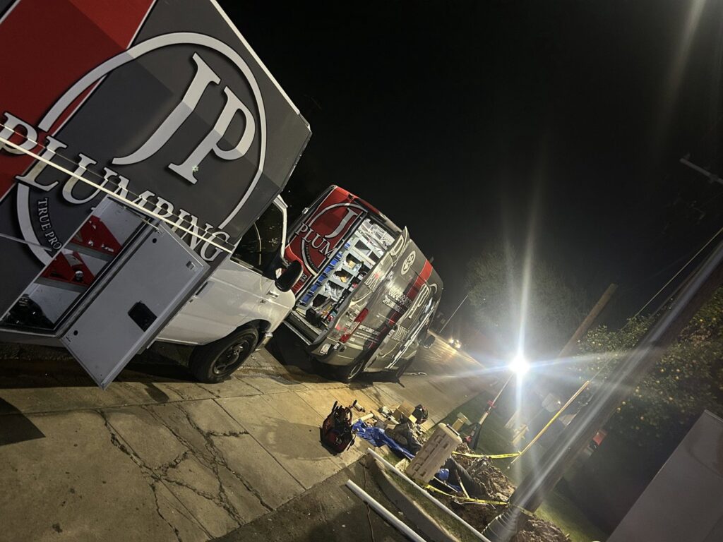A plumber from JP Plumbing working on copper and PVC pipes with a torch, performing a repair or installation in Phoenix, AZ