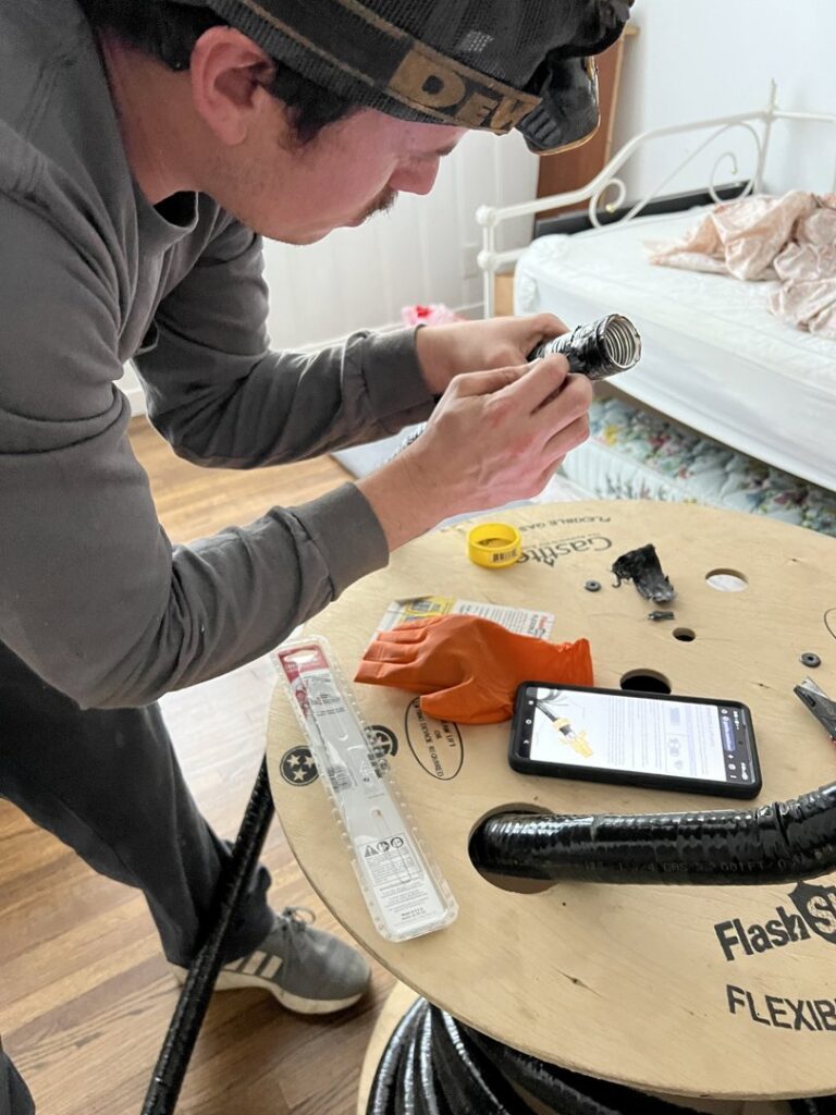 A Molberg Plumbing technician working on a pipe installation with tools in Ft Worth, TX