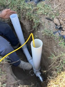 A Molberg Plumbing technician working on underground pipes in a trench in Ft Worth, TX