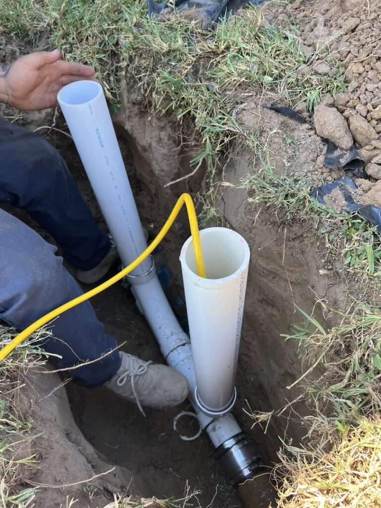 A Molberg Plumbing technician working on underground pipes in a trench in Ft Worth, TX