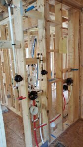 Plumbing rough-in installation in a new construction framed wall by All About the Pipes in Charlotte, NC.