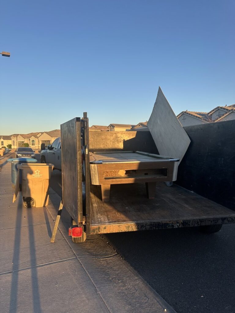 A pool table and other large items loaded onto a trailer for junk removal by Power Haulers & Junk Removal LLC in Phoenix, AZ.
