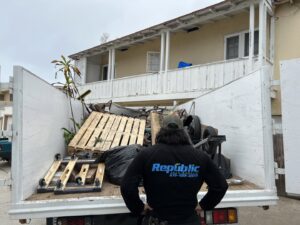 A Republic Junk Removal truck loaded with pallets, bags, and various debris after a job in San Diego, CA