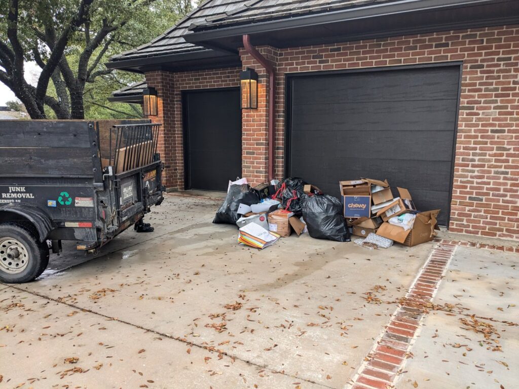 A pile of residential junk, including trash bags and cardboard boxes, ready for pickup by Herrera Hauling & Junk Removal in Fort Worth, TX.