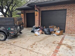 A pile of residential junk, including trash bags and cardboard boxes, ready for pickup by Herrera Hauling & Junk Removal in Fort Worth, TX.
