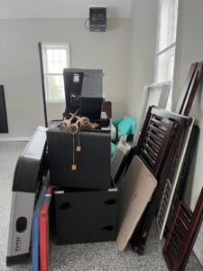 A room filled with old furniture, crib parts, and windows, awaiting junk removal by ABC Junk Removal & Hauling in Westfield, IN.