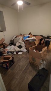 A cluttered room filled with moving boxes and household items, ready for junk removal by All Needz Junk Removal & Hauling Service in Dallas, TX.