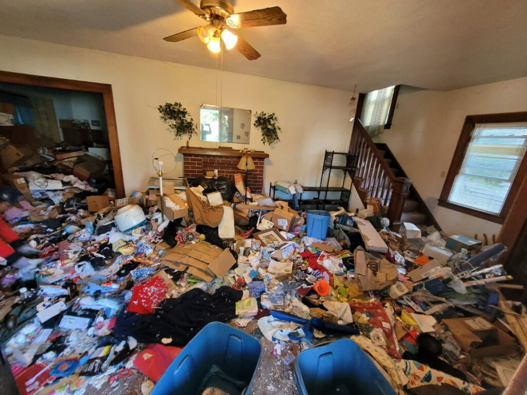 An entire room overflowing with trash, clothes, and various junk, representing a major cleanout job by Purefoy's Professionals in Columbus, OH.