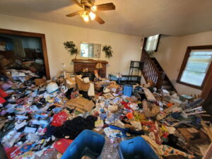 An entire room overflowing with trash, clothes, and various junk, representing a major cleanout job by Purefoy's Professionals in Columbus, OH.