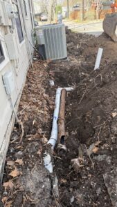 A trench showing old and new pipes during a sewer line replacement by Economy Plumbing Services in Austin, TX