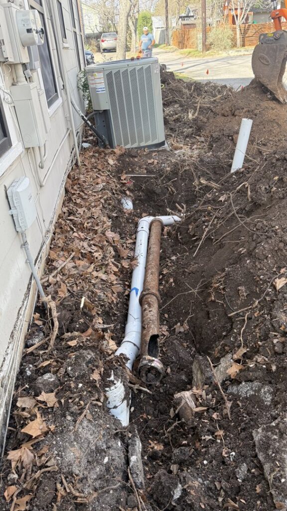 A trench showing old and new pipes during a sewer line replacement by Economy Plumbing Services in Austin, TX
