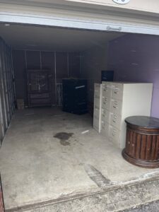 An empty storage unit with furniture, indicating a cleanout service by Junk Removal of Hancock County in Indianapolis, IN.