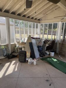 A sunroom filled with household clutter and old furniture, awaiting junk removal by G.I. HAUL in Austin, TX.