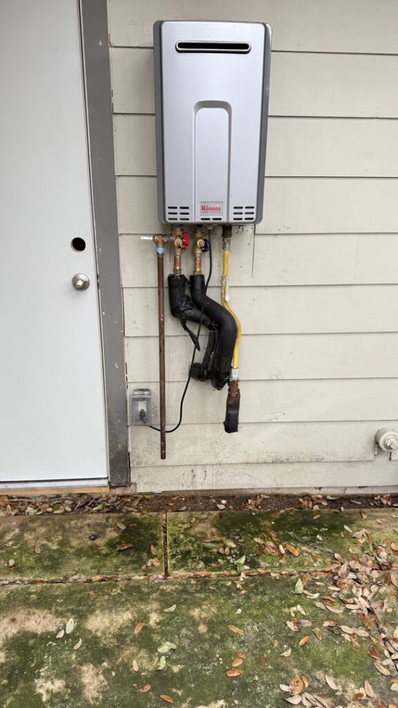 A newly installed outdoor tankless water heater by Economy Plumbing Services in Austin, TX