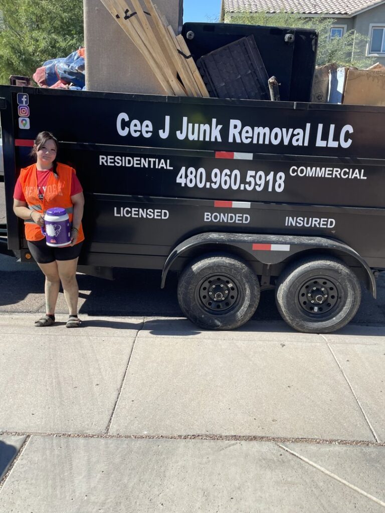 A Cee J Junk Removal LLC team member standing next to a loaded junk removal trailer in Phoenix, AZ.