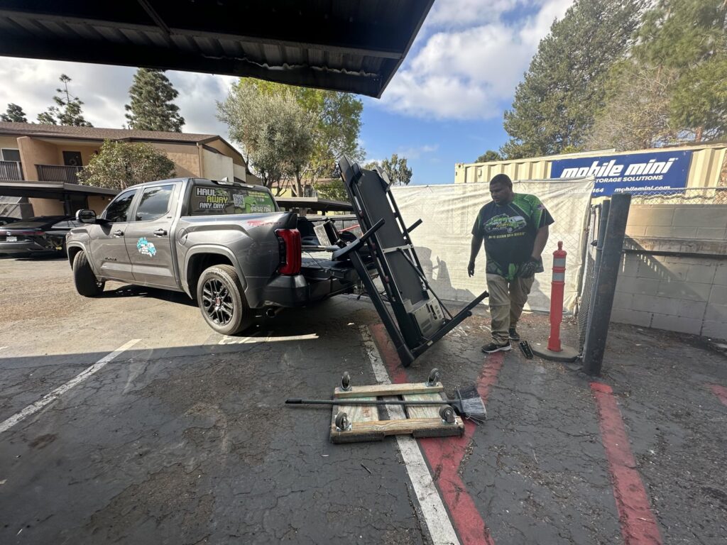 A Haul Away Any Day team member moving a treadmill for removal in San Diego, CA.