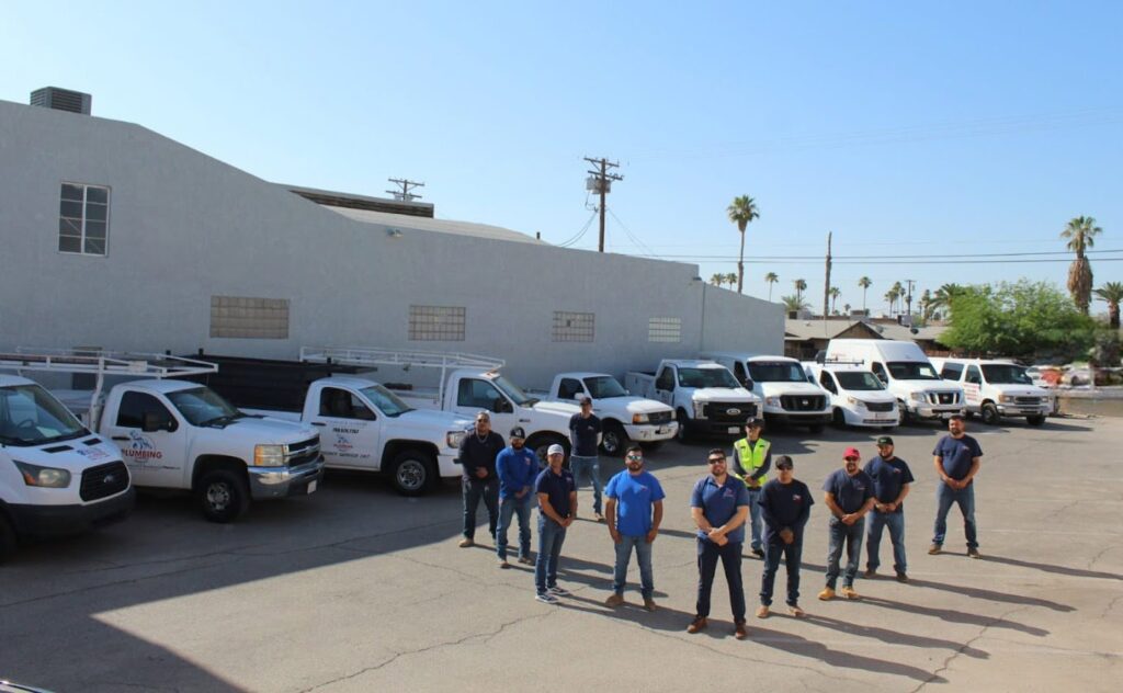 The team of professional plumbers from Plumbing Services Inc. standing with their service vehicles in San Diego, CA.