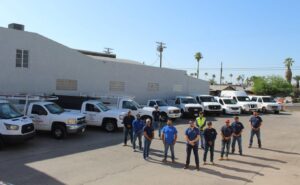 The team of professional plumbers from Plumbing Services Inc. standing with their service vehicles in San Diego, CA.