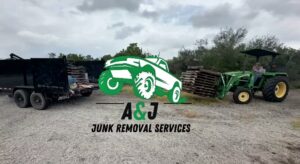 A tractor moving a stack of wooden pallets towards a dump trailer for removal by A&J Removal Service in San Antonio, TX.