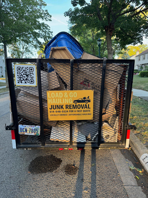 A Load & Go Hauling Junk Removal trailer filled with various items of junk after a residential pickup in Grove City, OH.