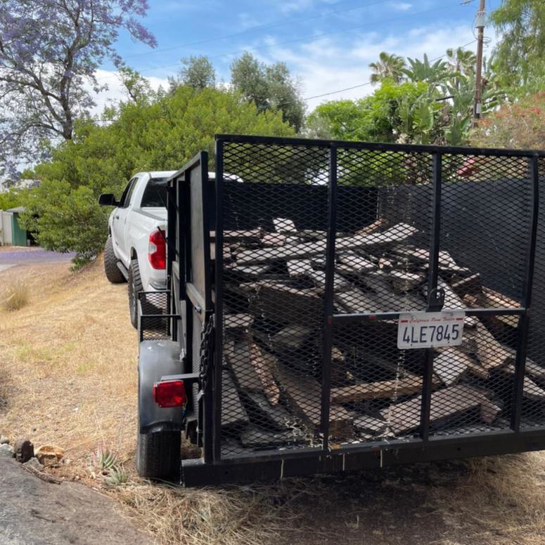 A trailer full of wood debris and junk, ready for removal by Dos Muchos Junk Removal LLC in San Diego, CA.