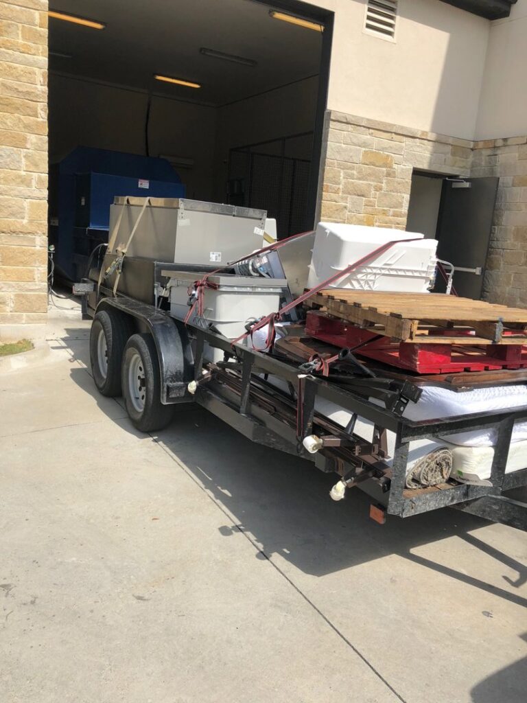 A trailer loaded with industrial equipment, pallets, and other items for removal by Perez Junk Removal in Anaheim, CA.
