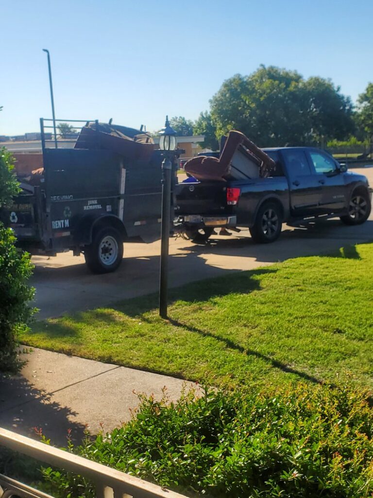 A truck from Herrera Hauling & Junk Removal hauling a trailer loaded with furniture and junk down a street in Fort Worth, TX.