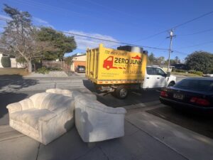 The back of a Zero Junk truck fully loaded with assorted furniture and household junk in San Jose, CA.