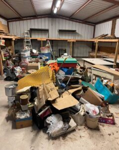 A large pile of assorted junk and debris inside a warehouse, ready for removal by G.I. HAUL in Austin, TX.