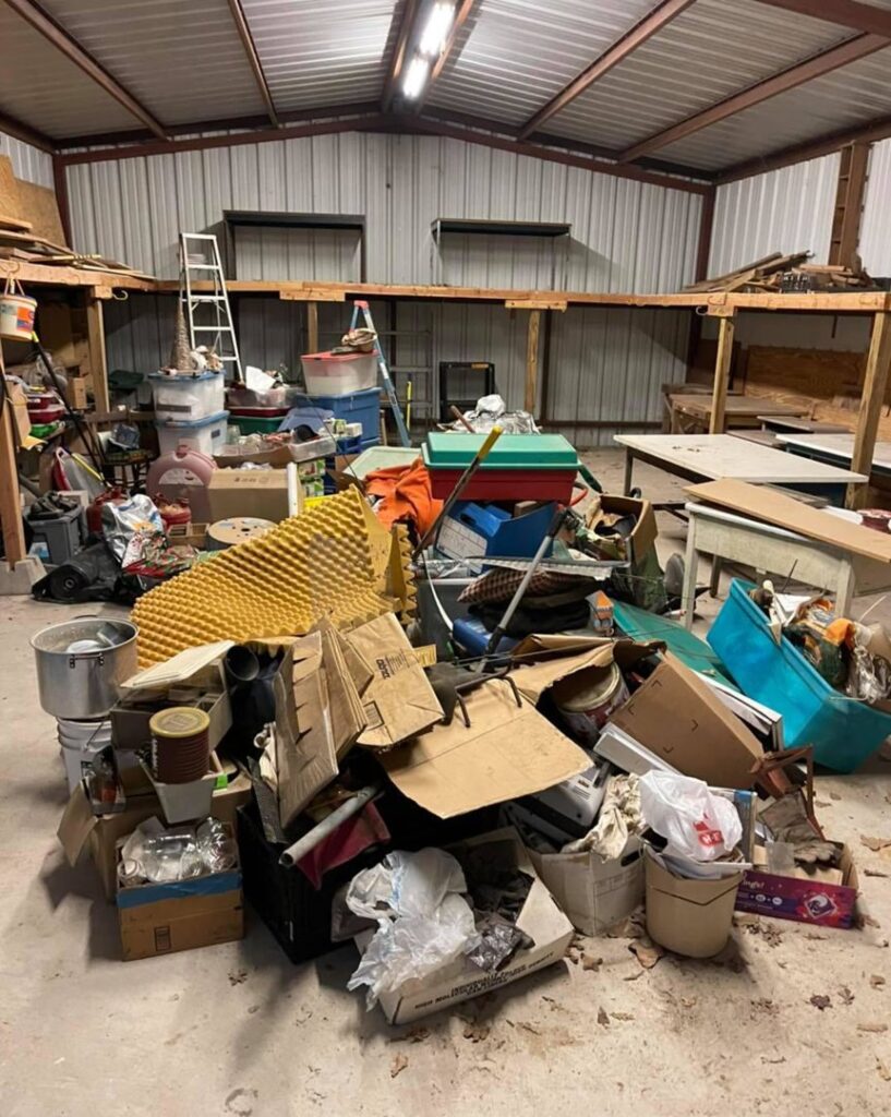 A large pile of assorted junk and debris inside a warehouse, ready for removal by G.I. HAUL in Austin, TX.