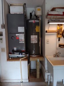 Water heater and utility sink area, showing plumbing setup by David Gray- Electrical Plumbing Heating & Air in Jacksonville, FL