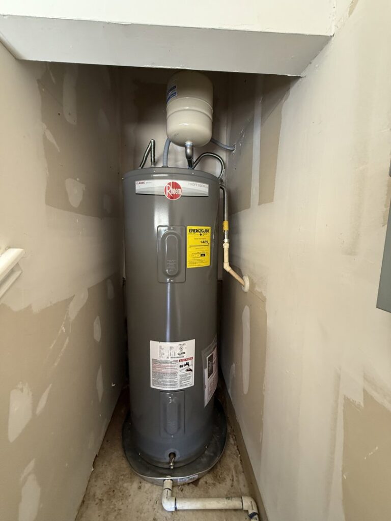 A water heater installed in a utility closet, showcasing plumbing services by The Bearded Plumber in San Antonio, TX.