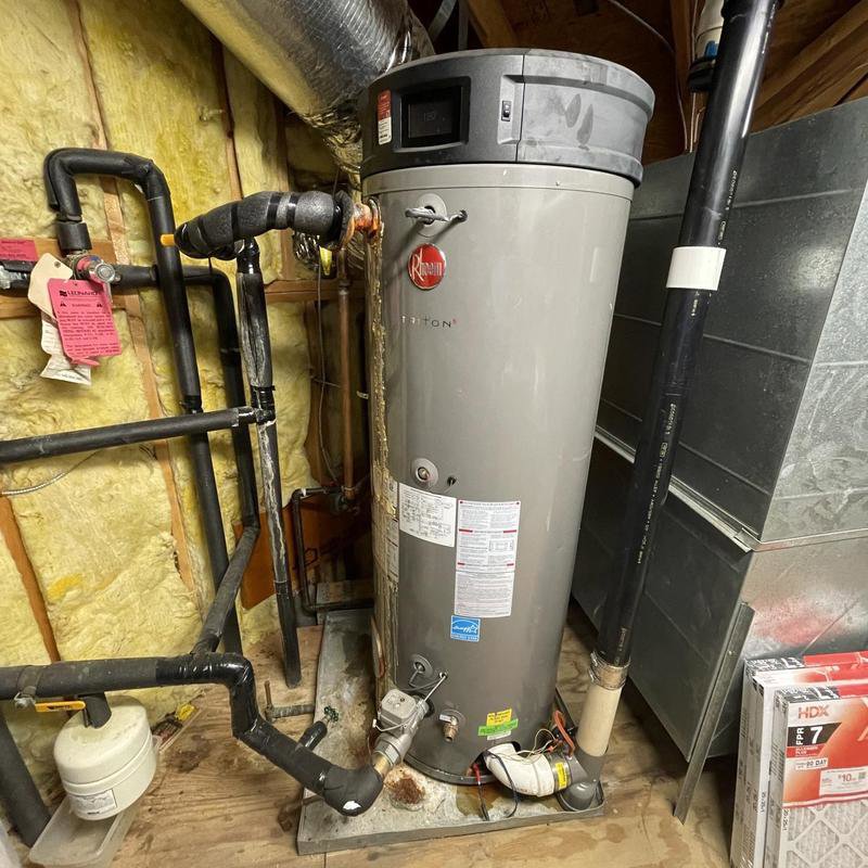 A large residential water heater with connected pipes, ready for installation or repair by Tribeca Plumbing in Dallas, TX.
