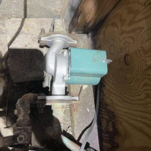 A water pump connected to plumbing lines, indicating installation or repair services by Tribeca Plumbing in Dallas, TX.