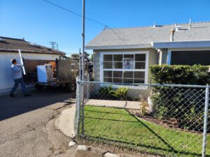 A worker carrying an item to a partially loaded junk removal trailer for 24/7 Junk Removal in Rolling Hills Estates, CA.
